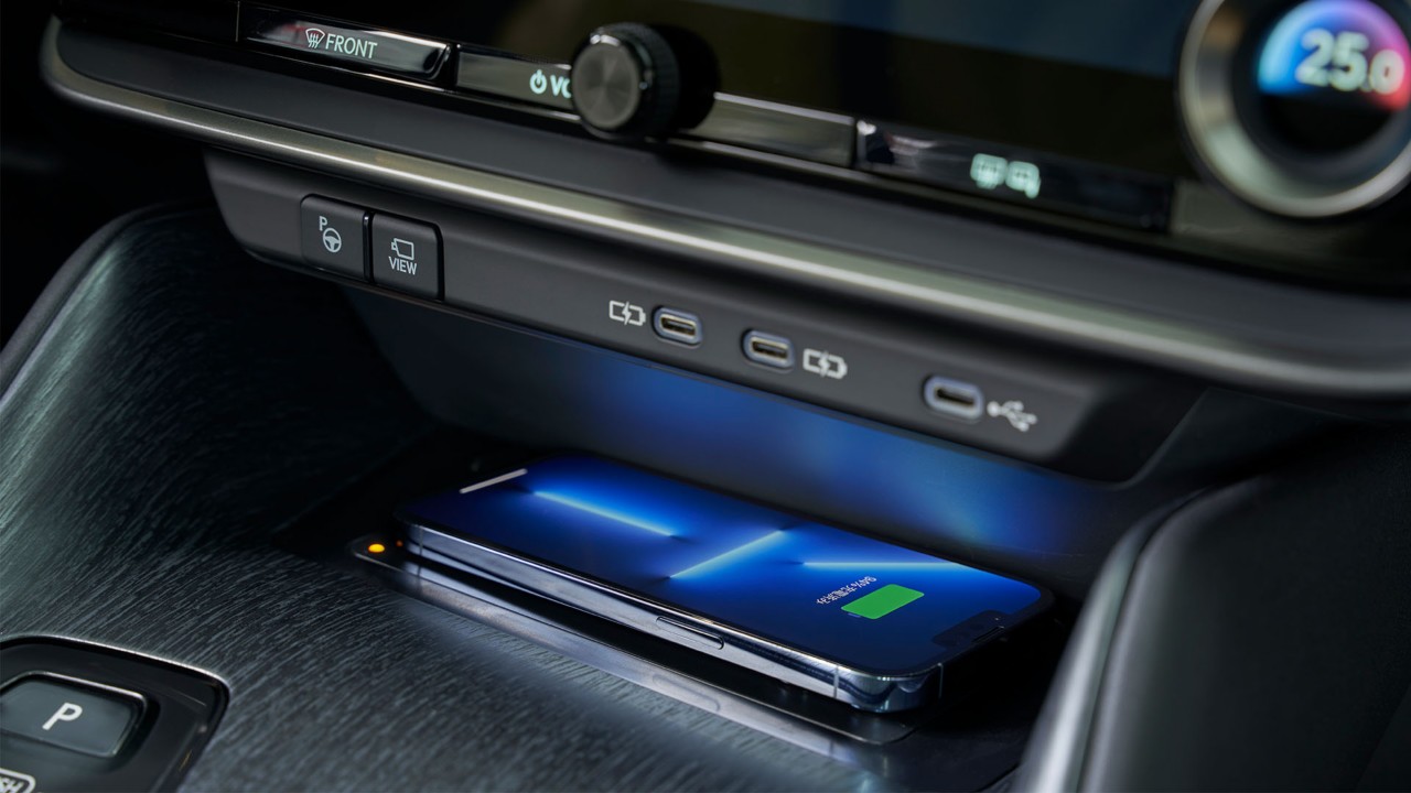 A mobile phone using the Lexus RZ 450e's wireless charger 