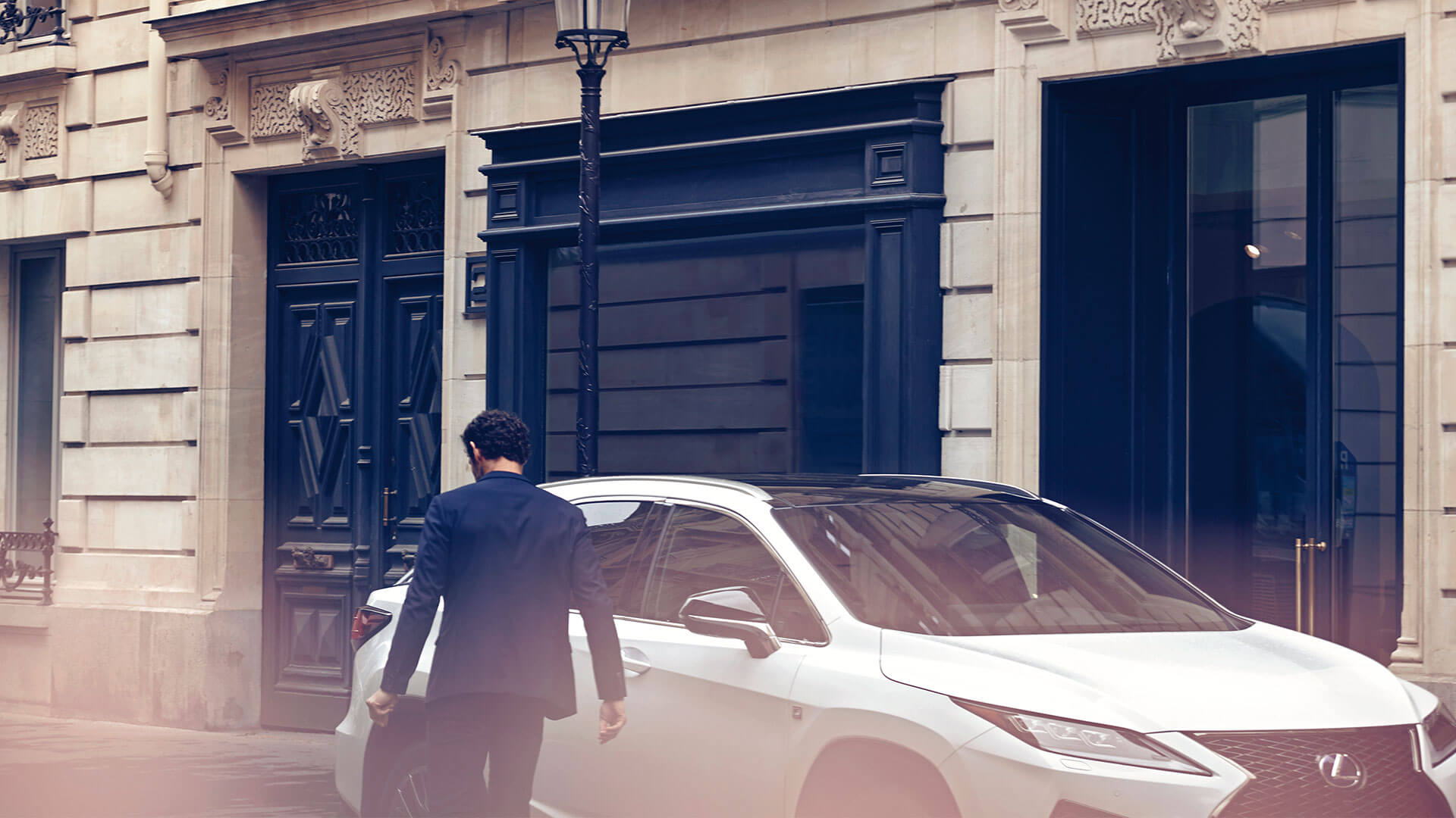 A man walking towards a parked Lexus RX 