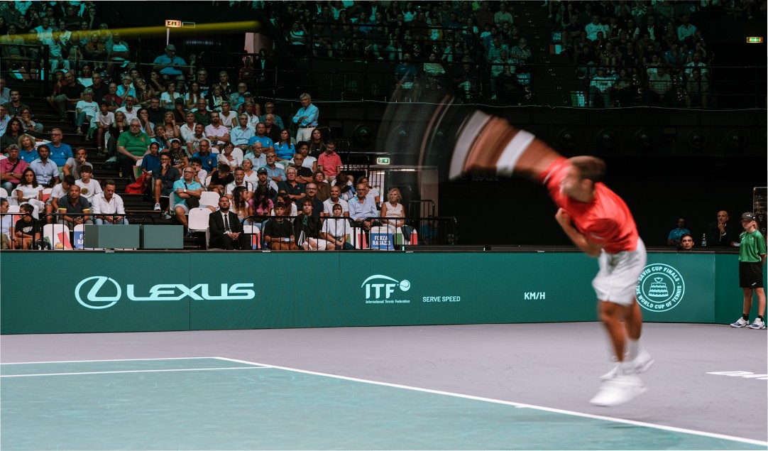 A tennis player serving on a Lexus X ATP court